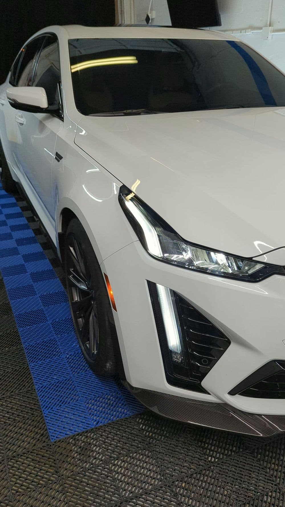 White luxury sedan with sleek design, modern headlights, and black alloy wheels.