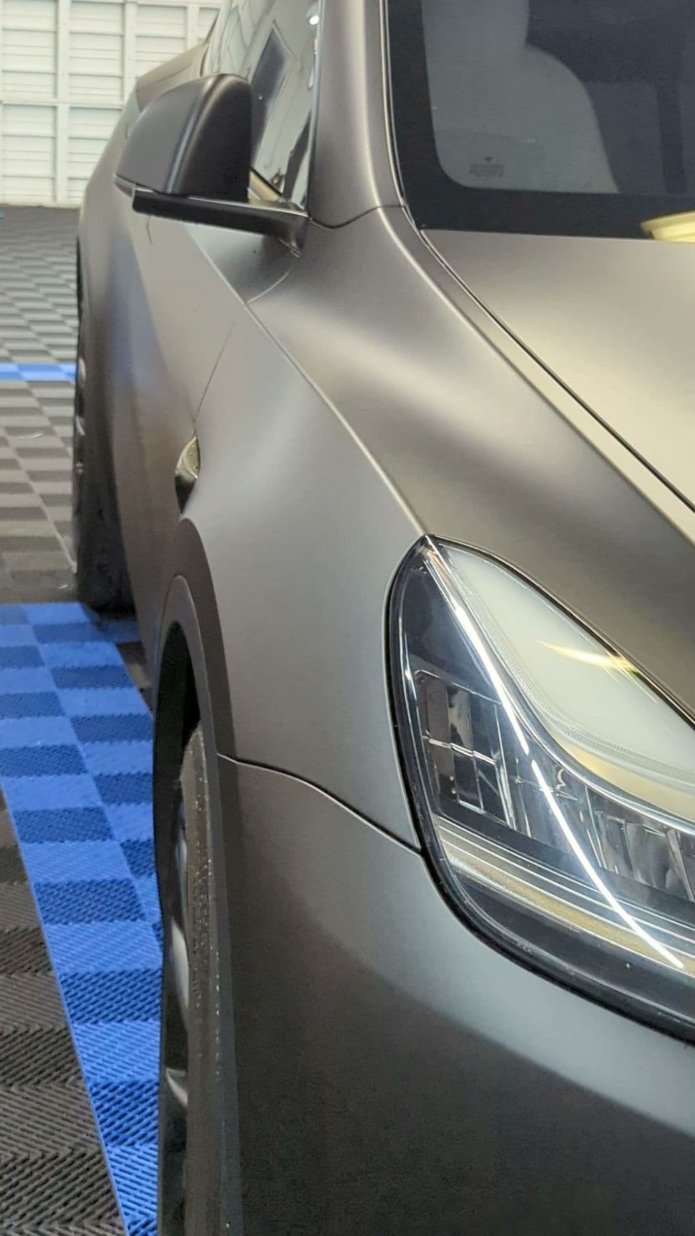 Matte black luxury car close-up with sleek design and modern headlight detail.