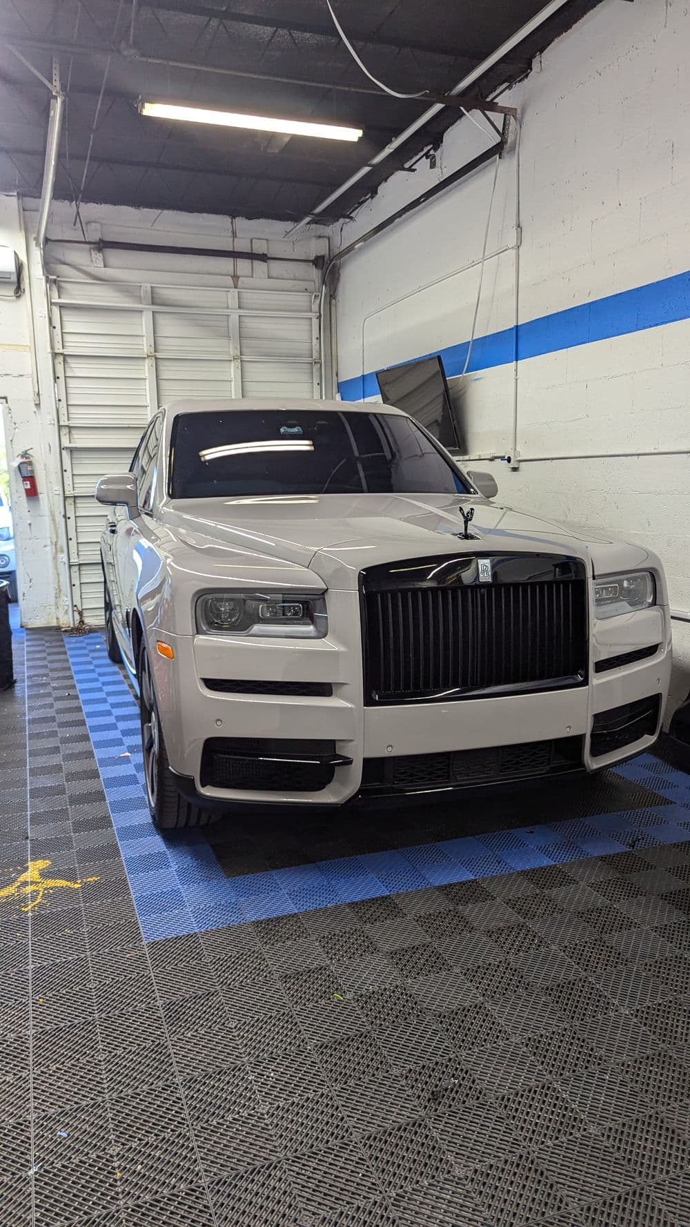 Rolls-Royce Cullinan luxury SUV in a garage with a sleek modern design and polished finish.