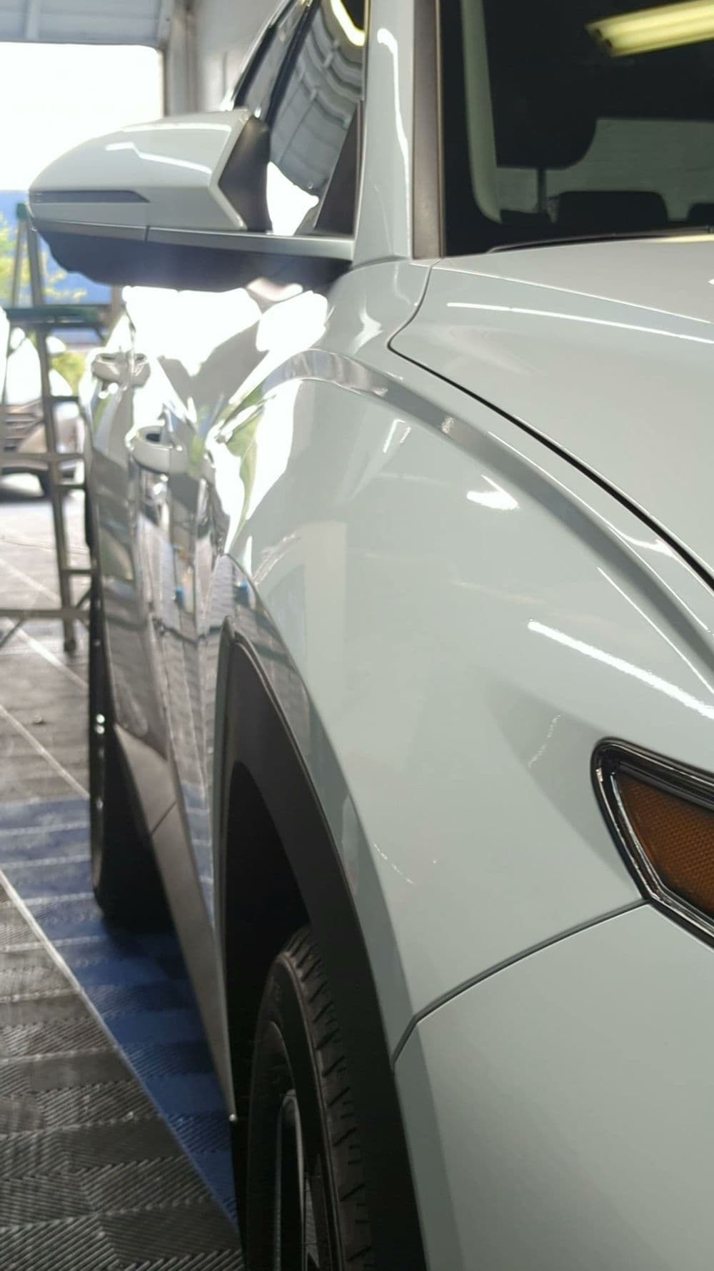Close-up of a shiny white SUV parked in a modern garage setting.