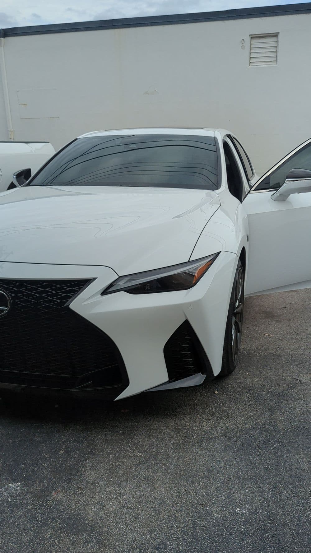 White Lexus IS with open door showcasing sleek design and modern styling.