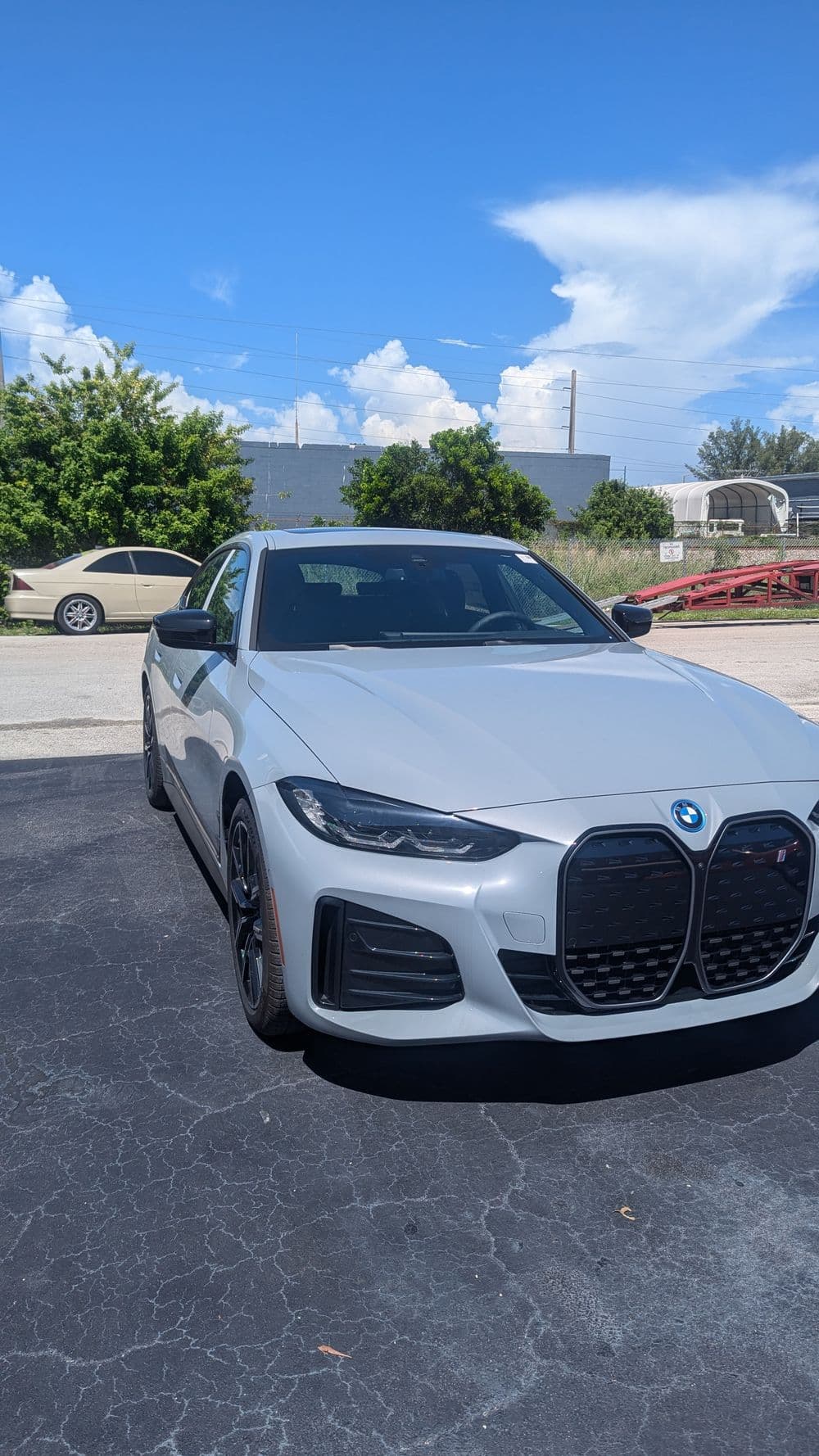 Silver BMW electric sedan parked, showcasing its distinctive front grille and sleek design.
