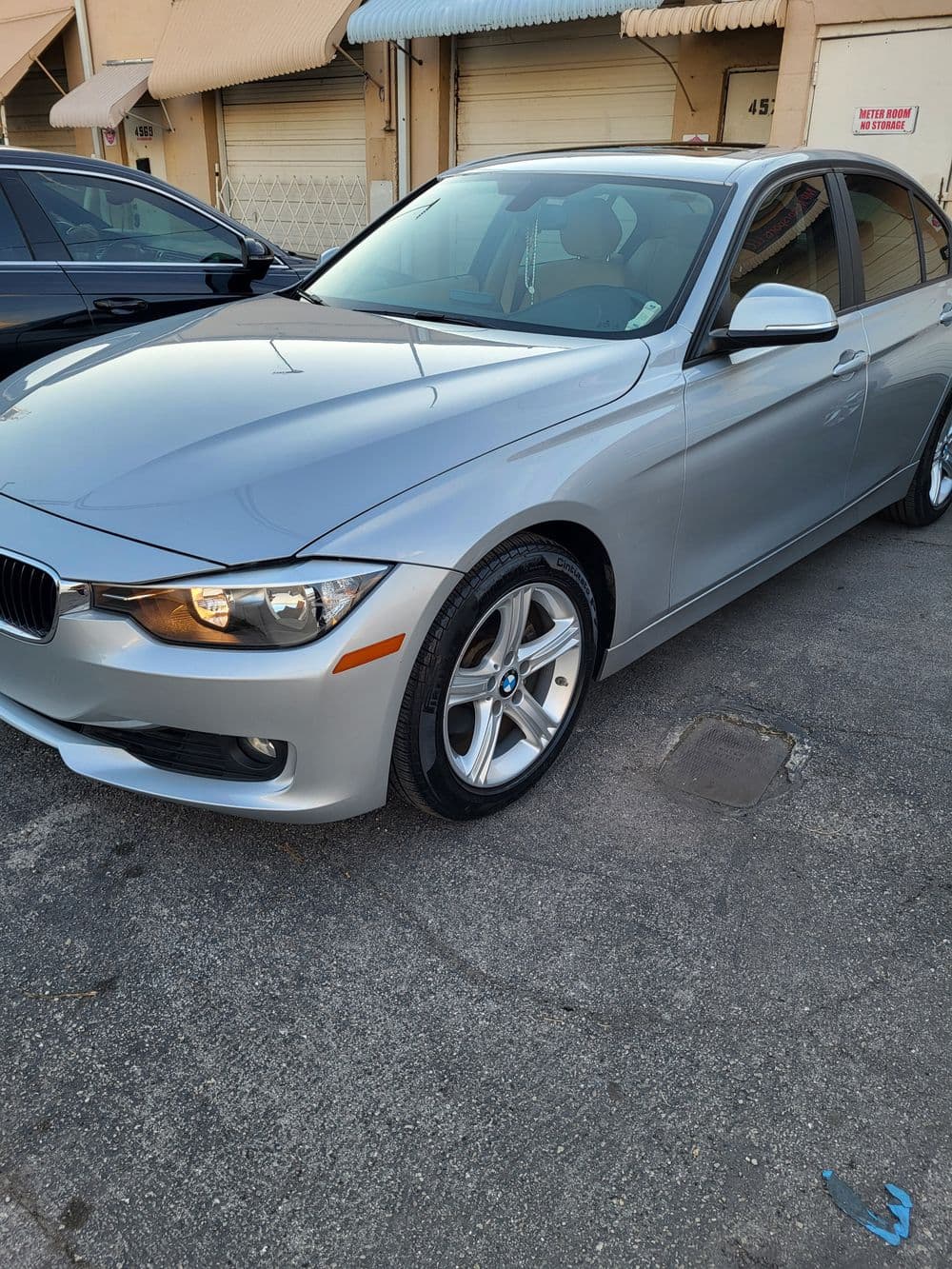 Silver BMW 3 Series sedan parked on the street, showcasing its sleek design and alloy wheels.